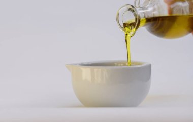 Zeytinyağı. İspanya zeytinyağı ve domatesli cam şeffaf kâse. Yakın plan, beyaz arkaplanda izole.