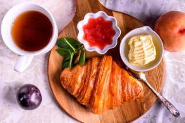 Croissant with tea and jam for breakfast