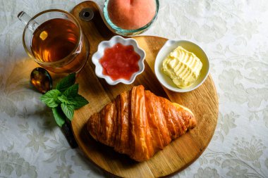 Croissant with tea and jam for breakfast