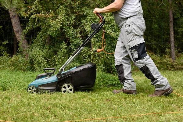Man Mowing Lawn in garden