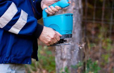 Bahçe işçisi bahçesinde gübreleme çimenliği ile.