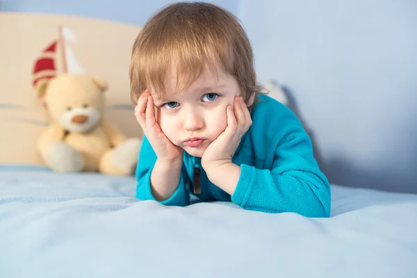 Portrait d'un garçon heureux de 3 ans couché sur le lit — Photo