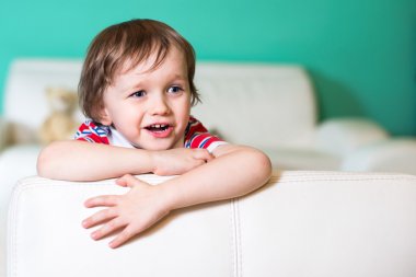 mutlu 3 yıl Beyaz deri koltukta oturan erkek bebek