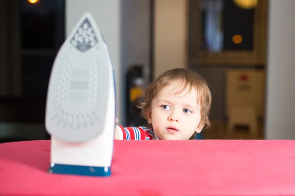 Kleine babyjongen is het bereiken van te heet strijkijzer — Stockfoto