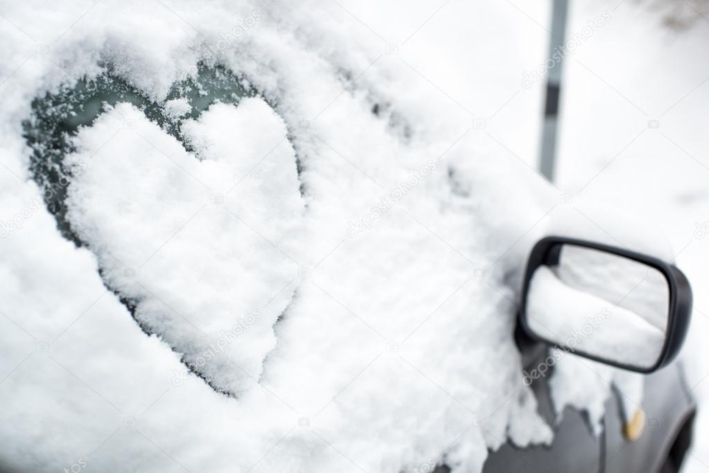 Buried by snow car with heart on side window