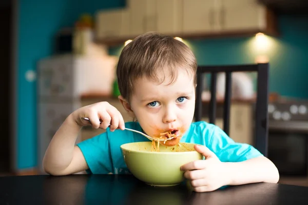 Menino está comendo espaguete — Fotografia de Stock