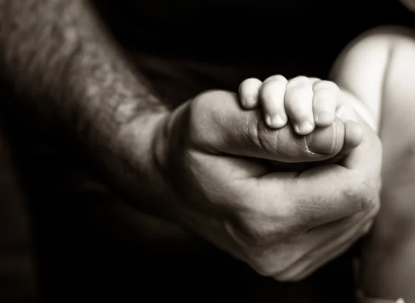 Baba, oğlunun elini tutarak