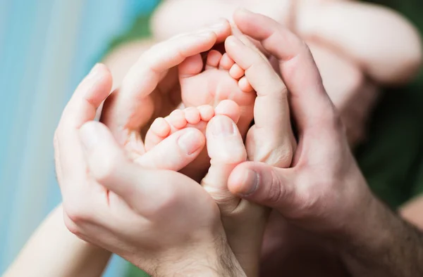 Pieds de bébé sur les mains des parents — Photo