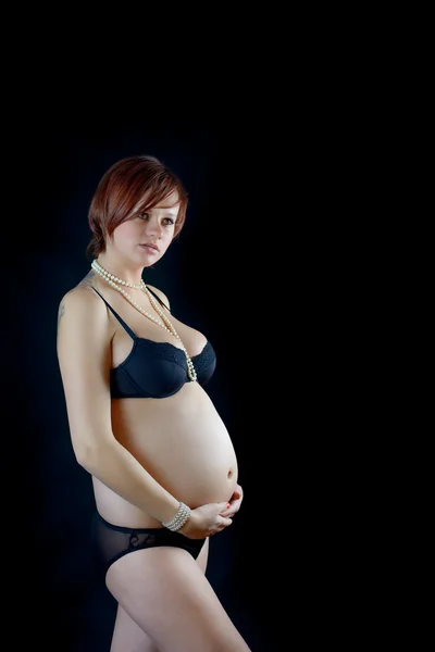 Femme enceinte sur fond noir — Photo