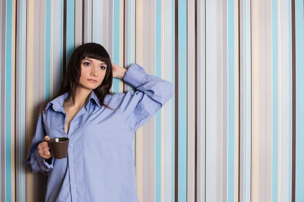 Mulher de camisa azul segurando uma xícara de café — Fotografia de Stock