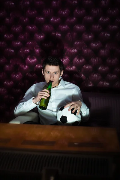 Homem com cerveja e bola de futebol assistindo TV — Fotografia de Stock