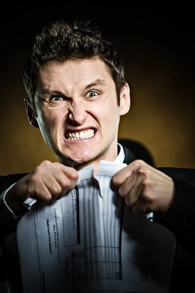 Angry businessman tearing document — Stock Photo, Image