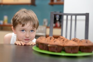 4 year old boy hungrily looking at chocolate cake clipart