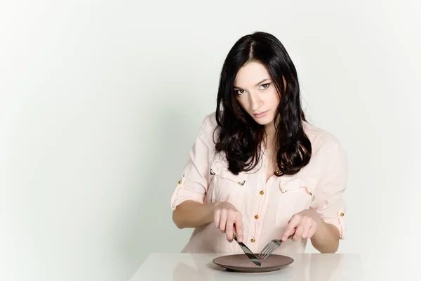 Hermosa morena fingiendo comer comida — Foto de Stock