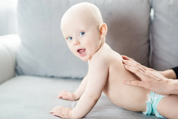 Moeder de achterkant van zijn 6 maanden oude baby masseren — Stockfoto