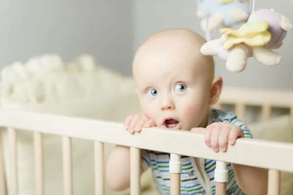 Küçük bebek beşiğinde ayakta — Stok fotoğraf