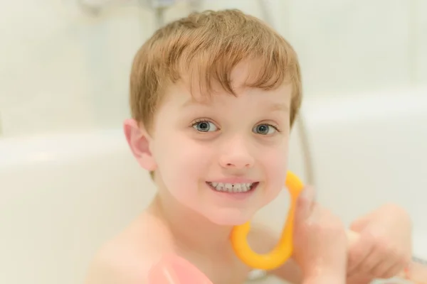 Menino de 4 anos toma banho na banheira com brinquedos — Fotografia de Stock