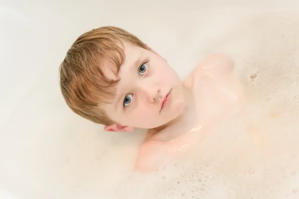 4-летний грустный мальчик купается в тубе — стоковое фото