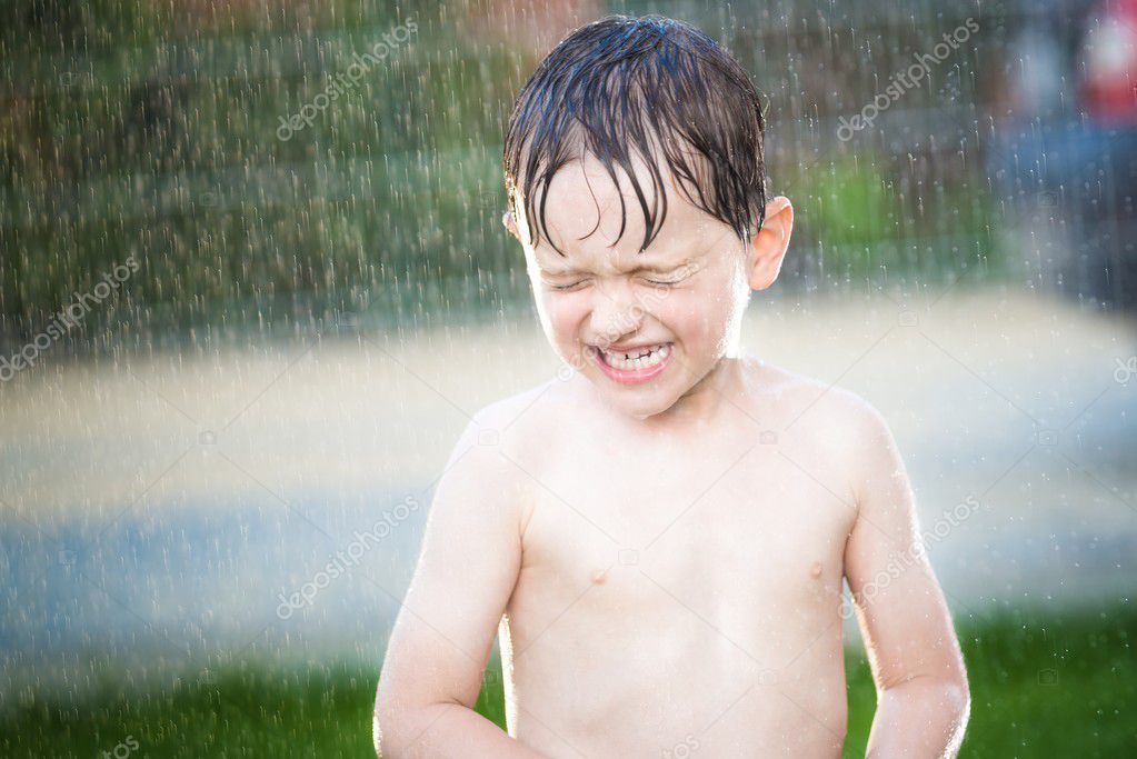 little boy having fun while summer rain