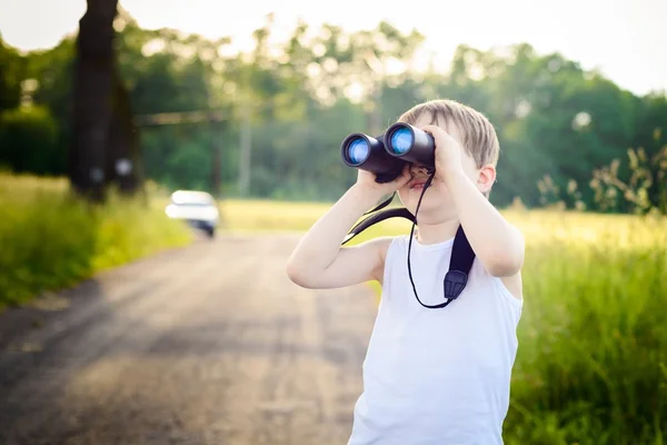 Niño mirando a través de los prismáticos — Foto de Stock