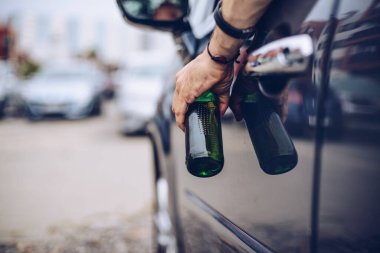 Sarhoş sürücü arabada alkol içiyor ve elinde bira tutuyor.