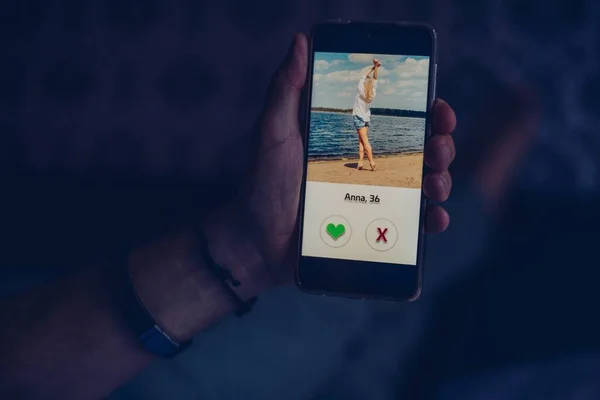 Mann benutzt Dating-App und wischt Nutzerfotos. — Stockfoto