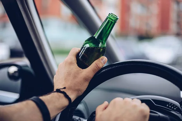Пьяный водитель, пьющий алкоголь в машине и держащий пиво — стоковое фото