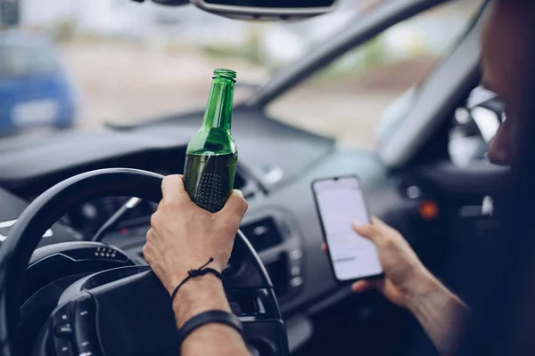 Conductor borracho bebiendo alcohol en el coche y usando el teléfono — Foto de Stock