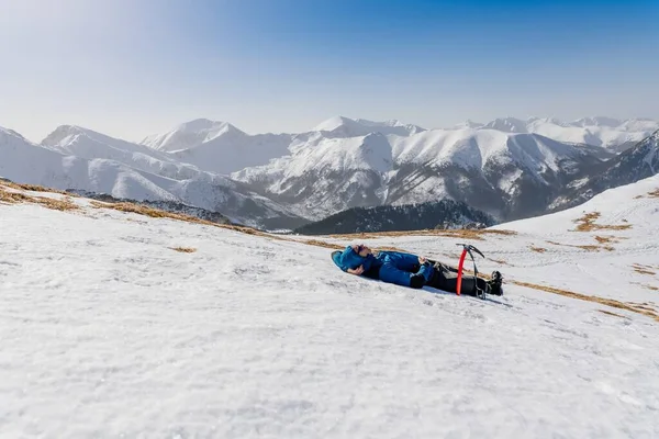 Άνθρωπος πεζοπόρος περιοδεύει ξεκουράζεται στο χιόνι — Φωτογραφία Αρχείου