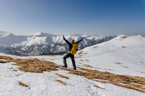 Kazmalı bir yürüyüşçü Polonya Tatra dağlarında poz veriyor.