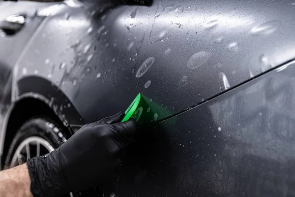 Carro detalhando trabalhador estúdio aplicando folha transparente — Fotografia de Stock