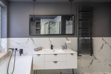 Gri duvarları ve beyaz banyosu olan modern düz banyo.