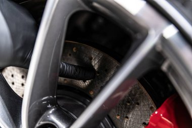 car mechanic in the garage looks at sports car brakes and brake discs