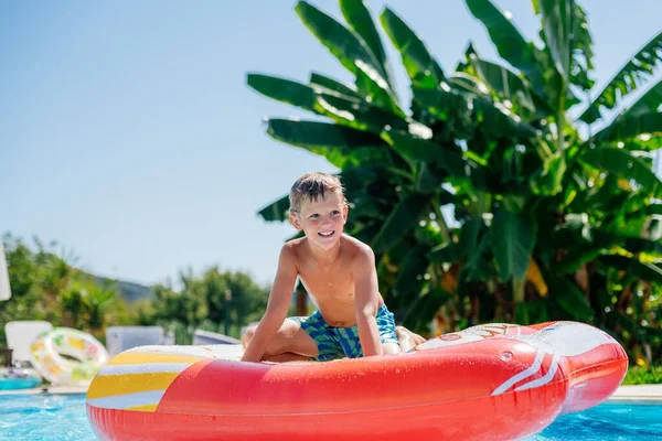 子供の男の子はギリシャのコーフのプールでインフレータブルホイールで遊んでいます 夏休み明けましておめでとう — ストック写真