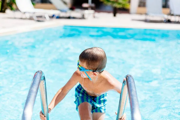 8歳の少年はプールの幸せを残します ギリシャのコルフでの幸せな休暇に — ストック写真