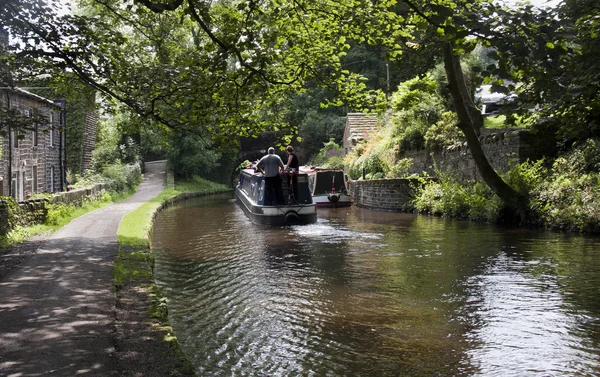 A narrowboat approaches a bridge on the Huddersfiled Narrow cana — Stock Photo, Image