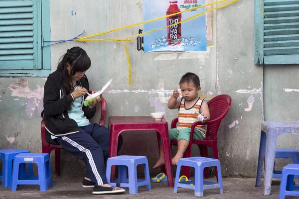 HO CHI MINH CITY,VIETNAM-NOV 5TH: Young girl and boy eating brea