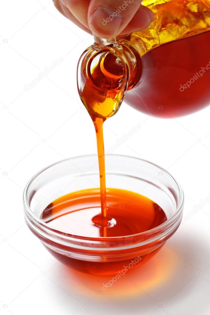 Pouring red palm oil into a glass bowl