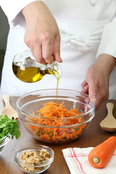 Maken geraspte wortel salade, gieten olijfolie — Stockfoto