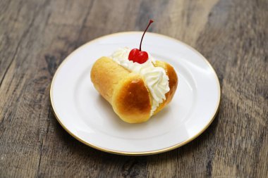 rum baba ( baba au rhum ) decorated with whipped cream; traditional French and Italian dessert