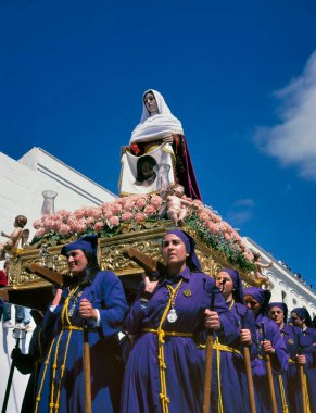 ARCOS DE LA FRONTERA, SPAIN-APRIL, 21 2000: Geçit törenine katılmak için düzenlenen törende bir grup kadın taşıyıcı (Tronos olarak da bilinir) dini bir şamandıra taşıyor.