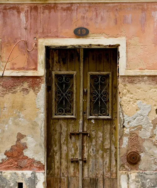 Porta antiga em uma casa com textura de parede de pedra desgastada . — Fotografia de Stock