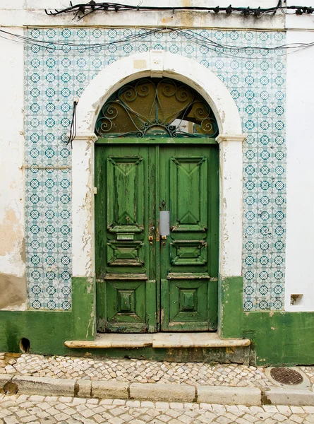 Porta antiga em uma casa com parede de azulejos usados . — Fotografia de Stock