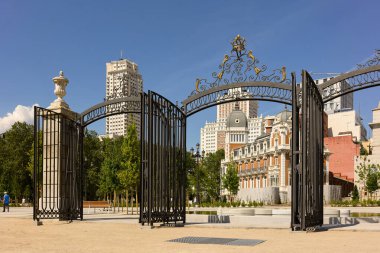 Madrid, İspanya - 10 Mayıs 2022. Yeni Plaza de Espana meydanı, ön planda Sabatini Gardens 'a giriş ve arka planda Madrid şehir merkezi silueti. Madrid, İspanya.