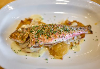 Grilled Red Mullet serverd over baked potatoes and dressing with chives