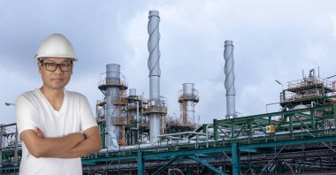 Endüstriyel petrol rafinerisinin önünde endüstriyel teknisyen duruyor..