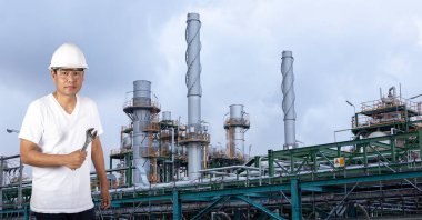 Endüstriyel mekanik teknisyenleri sanayi bölgesindeki endüstriyel petrol rafinerisinin önünde İngiliz anahtarı tutuyor..
