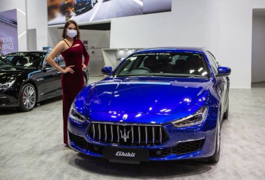 Nonthaburi, Thailand - March 24, 2022: Maserati Ghibli GT and female presenter displayed in Motor Show 2022