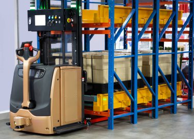 Automated Guided Vehicles (AGV) forklift lifting carton in modern warehouse.