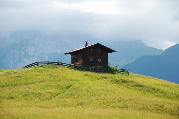 Коричневий каюті на пагорбі в Альпах Стокове Фото